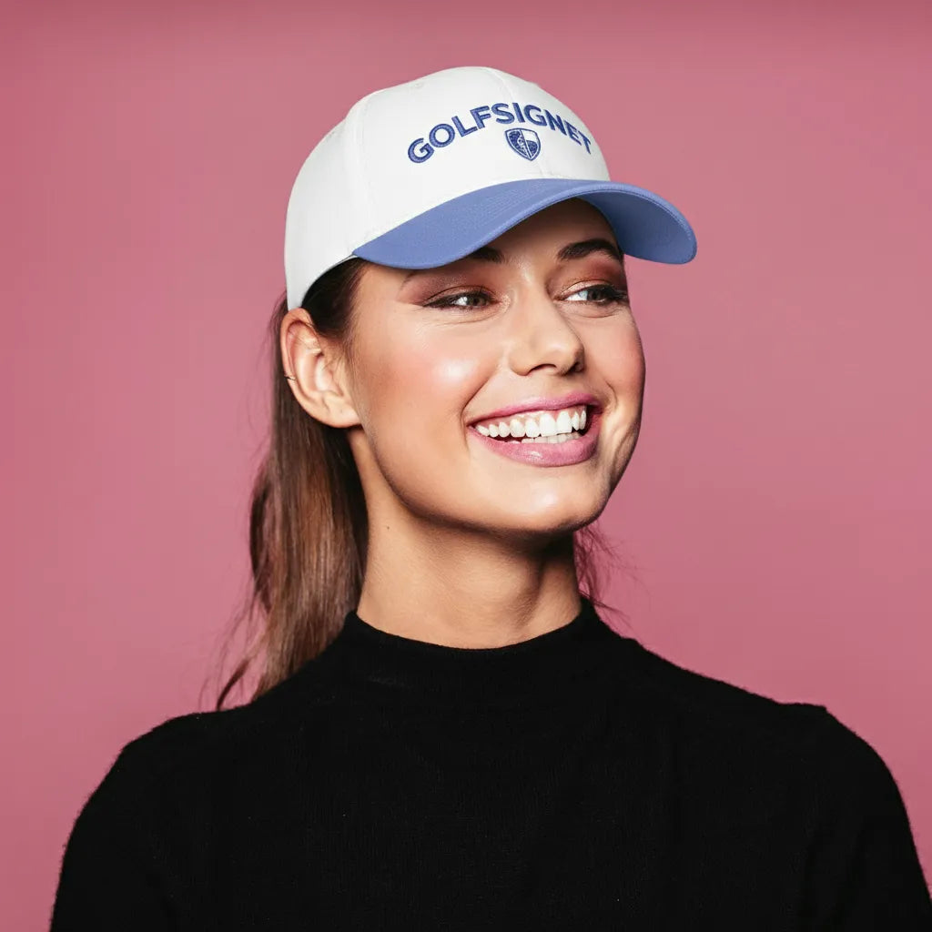 Woman wearing a white cap with 'GOLFSIGNET' logo on a pink background